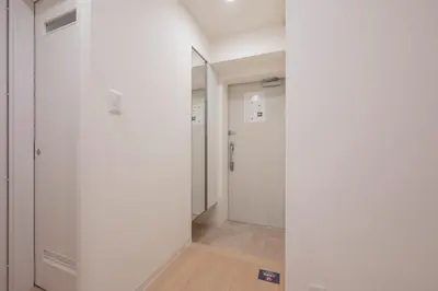 a hallway with white walls and a mirror at M S I Kagurazaka in Tokyo