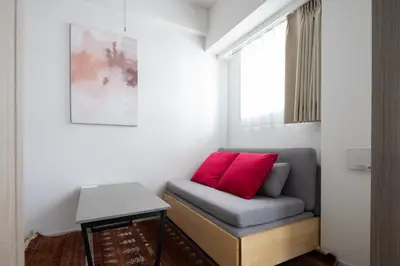 a couch with a red pillow in a room at \u30c7\u30a3\u30a2\u30ec\u30a4\u30b7\u30e3\u30b9\u672c\u6240\u543e\u59bb\u6a4bll in Tokyo