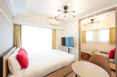 a bedroom with a bed and a tv and a couch at \u30c7\u30a3\u30a2\u30ec\u30a4\u30b7\u30e3\u30b9\u672c\u6240\u543e\u59bb\u6a4bll in Tokyo