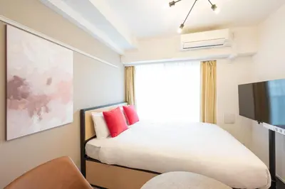 a bedroom with a bed with red pillows and a tv at \u30c7\u30a3\u30a2\u30ec\u30a4\u30b7\u30e3\u30b9\u672c\u6240\u543e\u59bb\u6a4bll in Tokyo