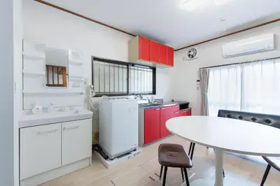 a kitchen with a white table and red cabinets at \u65b0\u5927\u585a\u6238\u5efa\u3066 in Tokyo