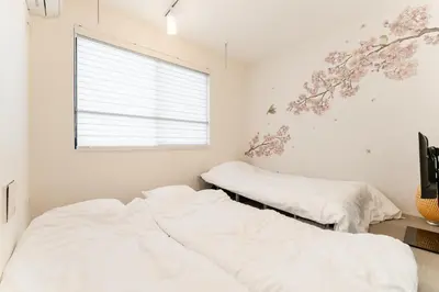 two beds in a bedroom with a window at Omotenashi HOTEL Asakusa in Tokyo
