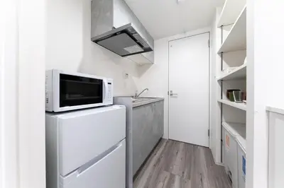 a kitchen with a microwave on top of a refrigerator at Omotenashi HOTEL Asakusa in Tokyo