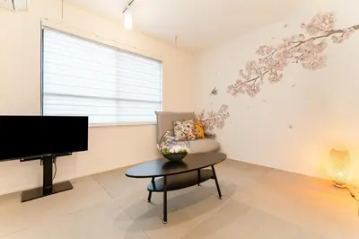 a living room with a tv and a chair and a table at Omotenashi HOTEL Asakusa in Tokyo