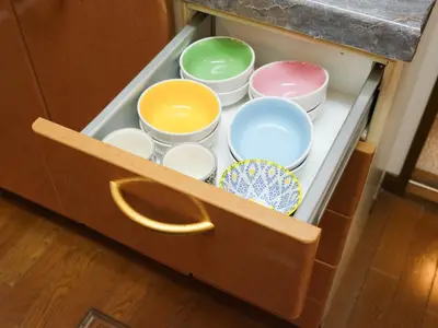 a drawer full of bowls and plates in a cabinet at Comfort HASUNUMA in Tokyo