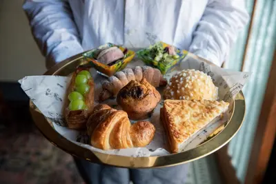 a person holding a plate of bread and pastries at Bamba Hotel Tokyo-Private Townhouse- in Tokyo
