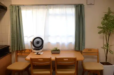 a room with a table with chairs and a fan at \u5143\u685c\u4e0a\u91ce\u6d45\u8349\u9ad8\u7d1a\u6c11\u6cca\u6700\u59278\u4eba\u99c56\u5206\u9ad8\u7d1a\u30d6\u30e9\u30f3\u30c9\u30d9\u30c3\u30c9\u5bb6\u5ead\u6620\u753b\u9928\u7121\u6599\u81ea\u8ee2\u8eca in Tokyo