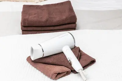 a hair dryer sitting on top of a pile of towels at Takakou building in Tokyo