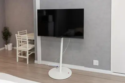 a flat screen tv on a wall in a living room at Takakou building in Tokyo