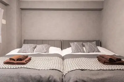 two beds with towels on top of them in a bedroom at Takakou building in Tokyo