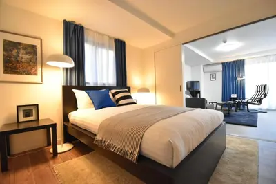 a bedroom with a large bed and a living room at LANG - Vacation STAY 22195v in Tokyo