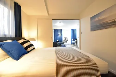 a bedroom with a large bed with blue pillows at LANG - Vacation STAY 22195v in Tokyo