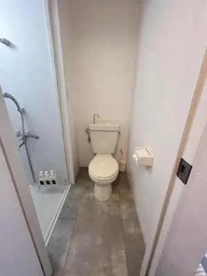 a small bathroom with a toilet and a shower at Hotel \u7c8bSUI Shinjuku in Tokyo