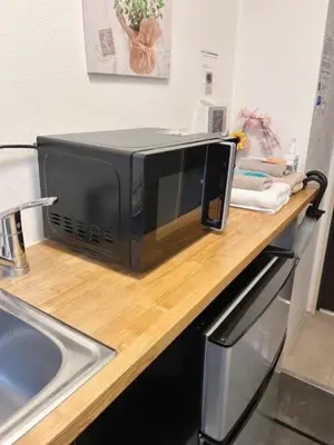 a microwave sitting on a counter next to a sink at Hotel \u7c8bSUI Shinjuku in Tokyo