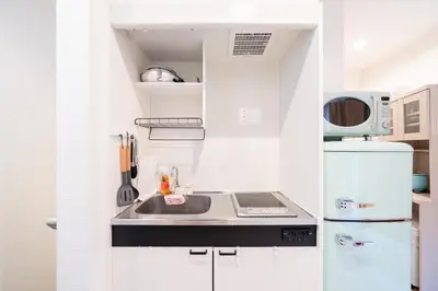 a small kitchen with a sink and a refrigerator at Direct access to major Tokyo stations including Shibuya, Shinjuku, Ikebukuro, Akihabara, and Ueno 3-minute walk from nearest station Tokyo Dome Suitable for long-term stays 201 in Tokyo