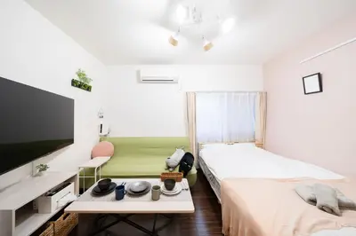a small bedroom with two beds and a tv at Direct access to major Tokyo stations including Shibuya, Shinjuku, Ikebukuro, Akihabara, and Ueno 3-minute walk from nearest station Tokyo Dome Suitable for long-term stays 201 in Tokyo