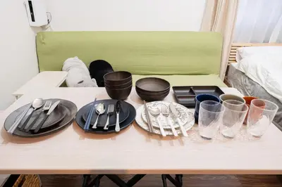 a table with plates and utensils on it at Direct access to major Tokyo stations including Shibuya, Shinjuku, Ikebukuro, Akihabara, and Ueno 3-minute walk from nearest station Tokyo Dome Suitable for long-term stays 201 in Tokyo