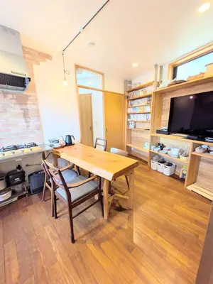 a dining room with a wooden table and a tv at Asukayama Forrest in Tokyo