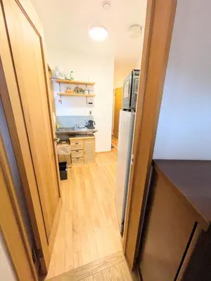 a hallway leading to a kitchen with a refrigerator at Asukayama Forrest in Tokyo