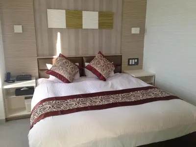 a bedroom with a large white bed with red pillows at Amand Hotel in Tokyo