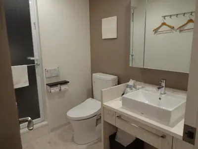 a bathroom with a toilet and a sink and a mirror at Amand Hotel in Tokyo