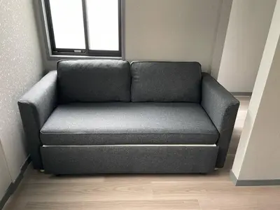 a gray couch in a room with a window at Rakuna Inn \u967d Sasazuka2 in Tokyo