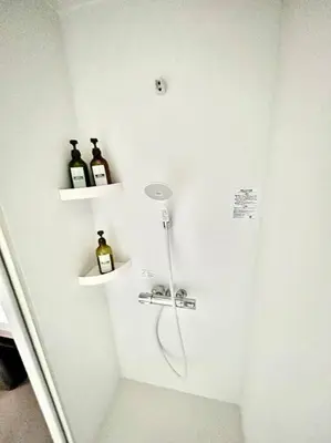 a bathroom with two bottles of wine on shelves at Rakuna Inn \u967d Sasazuka2 in Tokyo