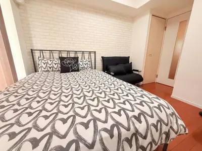 a bedroom with a black and white bed and a chair at Shibuya center-350m from Shibuya station S9 in Tokyo