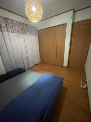 a bedroom with a bed with a blue comforter at Tommy's house 東京都内では貴重な無料駐車場付で大地震でも安心の新しい家 in Tokyo