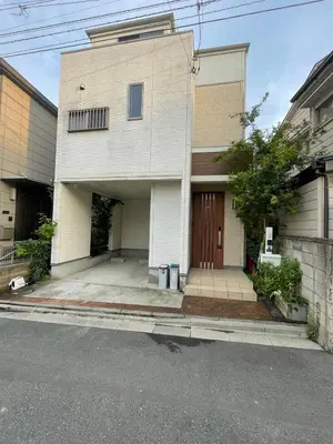 a white house with a garage and a driveway at Tommy's house 東京都内では貴重な無料駐車場付で大地震でも安心の新しい家 in Tokyo