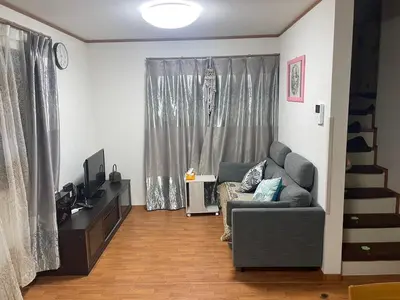 a living room with a gray couch and a window at Tommy's house 東京都内では貴重な無料駐車場付で大地震でも安心の新しい家 in Tokyo