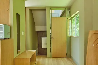 a kitchen with green walls and a wooden door at HATa in Tokyo
