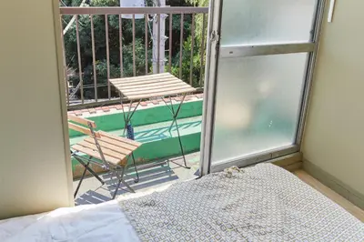 a balcony with a bed and a chair and a pool at HATa in Tokyo