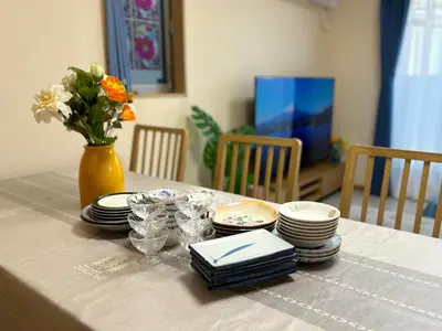 a table with plates and glasses and a vase with flowers at Lapis House 201 - 2F in Tokyo