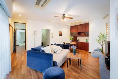 a living room with a couch and a blue chair at Shinjuku Skyview Serenity Duplex Villa in Tokyo