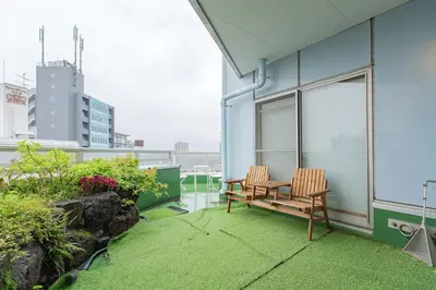 a patio with two chairs and a table on a building at Shinjuku Skyview Serenity Duplex Villa in Tokyo