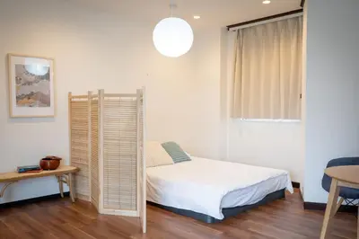 a small bedroom with a bed and a table at Shinjuku Skyview Serenity Duplex Villa in Tokyo