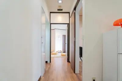 a hallway with white walls and wooden floors and a mirror at Shinjuku Skyview Serenity Duplex Villa in Tokyo
