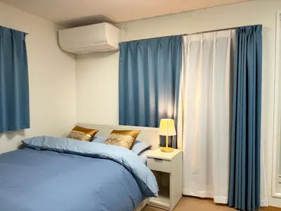 a bedroom with blue curtains and a bed and a lamp at Lapis House 201 - 3F in Tokyo