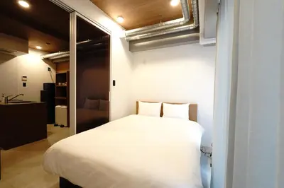 a bedroom with a large white bed in a room at MUSASHI Residence Morisita Station Front in Tokyo