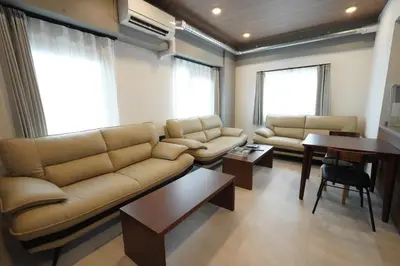 a living room with a couch and a table at MUSASHI Residence Morisita Station Front in Tokyo