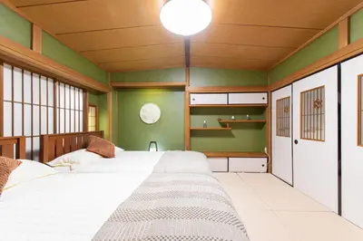 a bedroom with two beds and green walls at G\u65b0\u5bbf\u6700\u4e2d\u5fc3 \u4e24\u5ba4\u4e00\u5385 \u65b0\u5bbf\u4e09\u4e01\u76ee\u8f66\u7ad94\u5206 2 rooms Shinjuku center 4 mins to ST Max 7P \u76f4\u8fbe\u65b0\u5bbf \u6d89\u8c37 \u8868\u53c2\u9053 \u6c60\u888b \u4e0a\u91ce \u4ee3\u4ee3\u6728 \u94f6\u5ea7 \u539f\u5bbf \u54c1\u5ddd in Tokyo