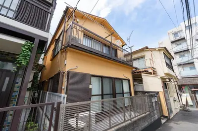 a yellow building with a balcony on a street at Shinjuku-ku - House - Vacation STAY 17230 in Tokyo