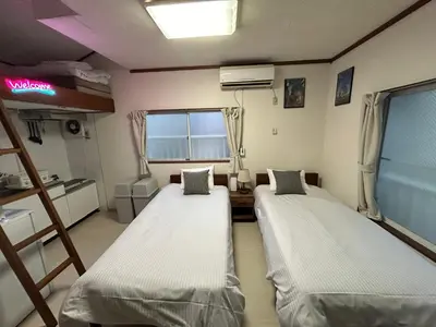 a room with two beds and a window at Kita LOVE House in Tokyo