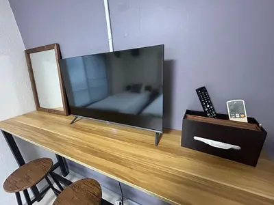 a television on a wooden table with two chairs at Kita LOVE House in Tokyo