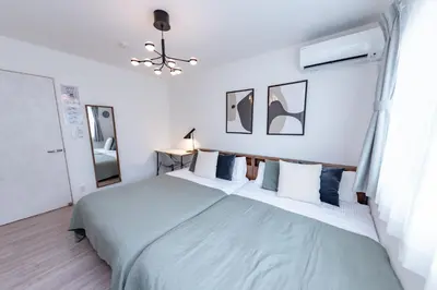 a white bedroom with a large bed with blue pillows at HOETL GOLD TOKYO - Vacation STAY 45153v in Tokyo