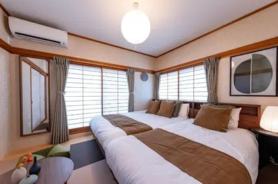 two beds in a room with windows at HOETL GOLD TOKYO - Vacation STAY 45153v in Tokyo