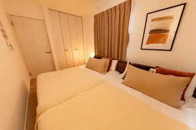 a bedroom with two beds with pillows at HOETL GOLD TOKYO - Vacation STAY 45153v in Tokyo