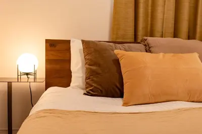 a bed with brown and white pillows and a lamp at HOETL GOLD TOKYO - Vacation STAY 45153v in Tokyo