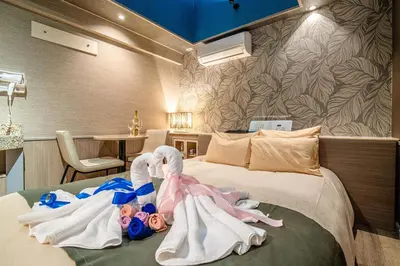 a bedroom with towels on a bed with a table at \u30db\u30c6\u30eb\u30ea\u30aa\u30b9\u6e0b\u8c37Adults only in Tokyo